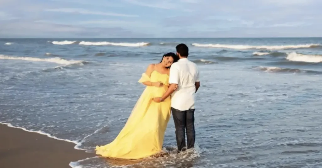 beach couple poses leaning on him with yellow dress