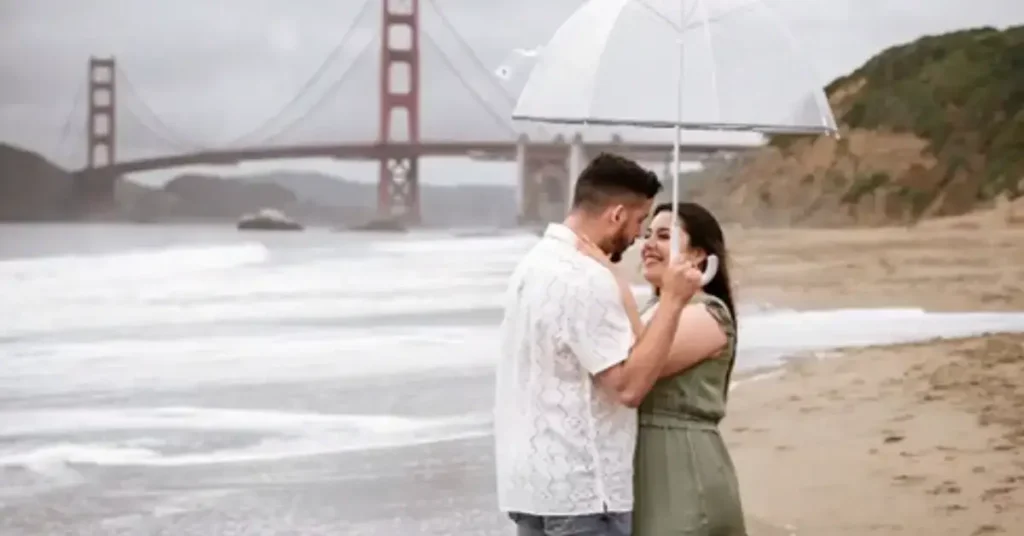 beach couple poses with an umbrella
