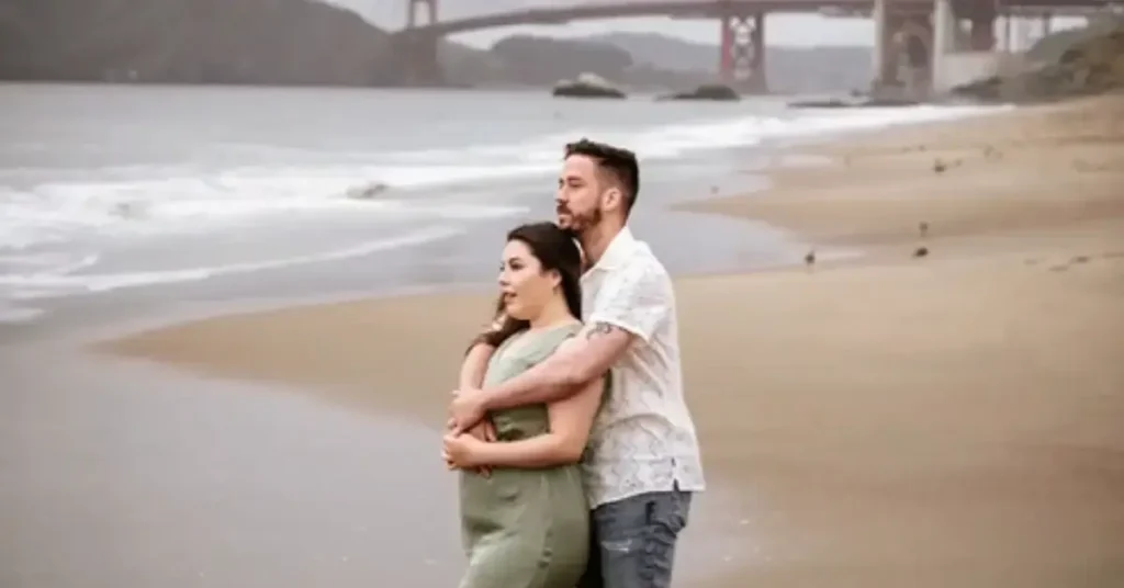 beach couple poses cuddling
