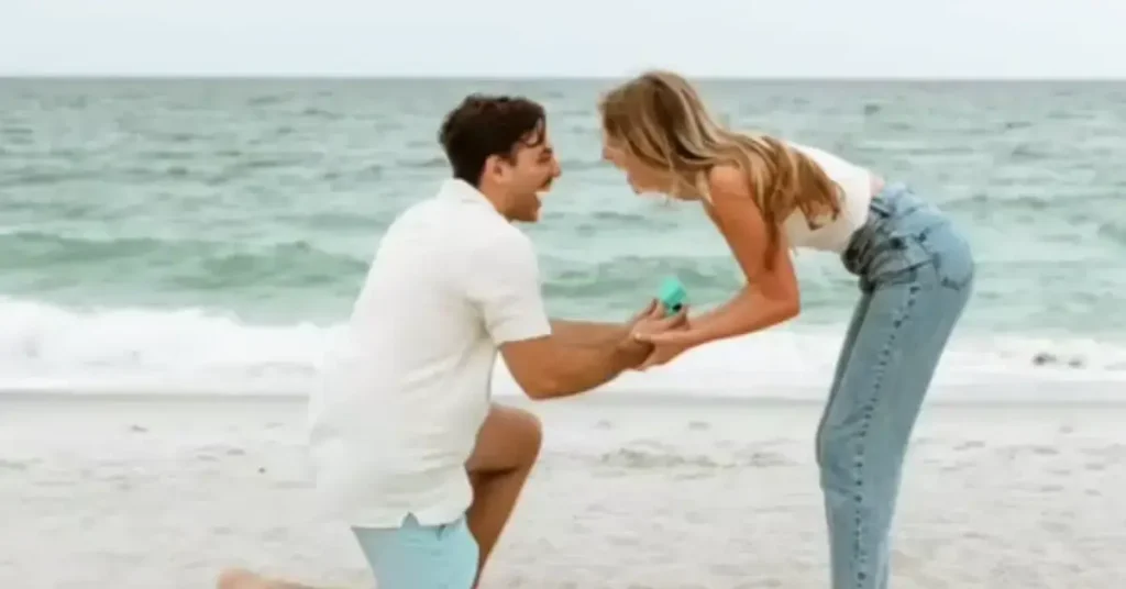 beach couple poses wedding ring