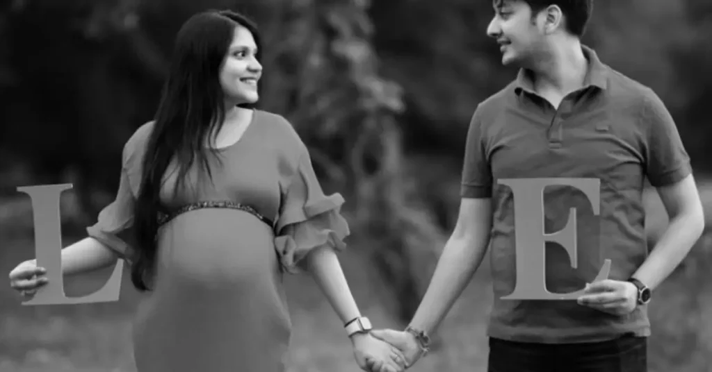 couple maternity poses holding love sign