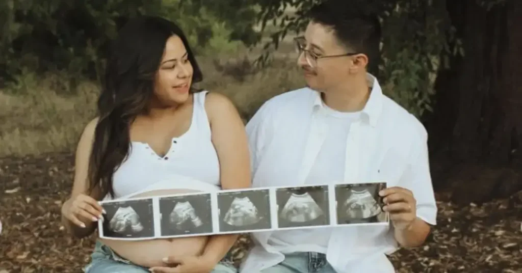 couple maternity poses holding 5 ultrasound photos
