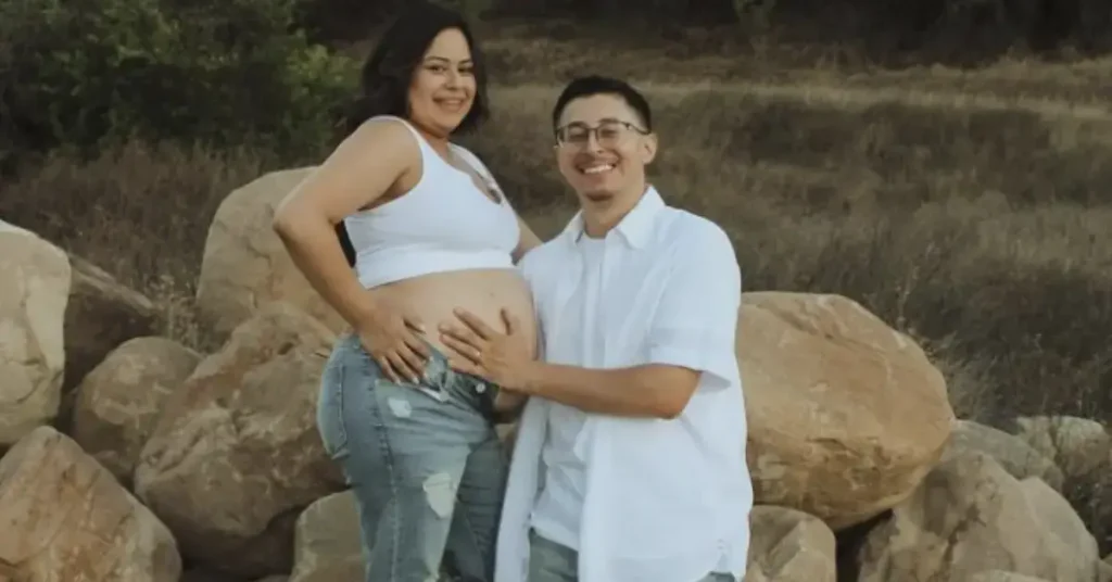 couple maternity poses hand on the belly outside