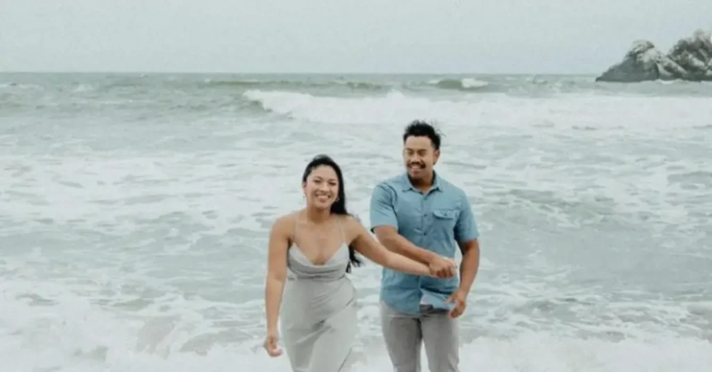 couple holding hands while beach couple photoshoot